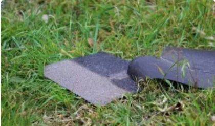 Asphalt shingles laying on grass