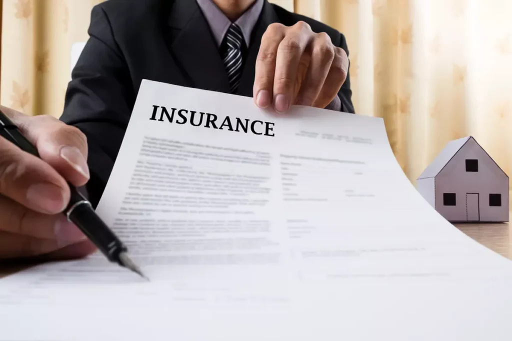 Person in suit pointing at an insurance policy’s text with a pen.