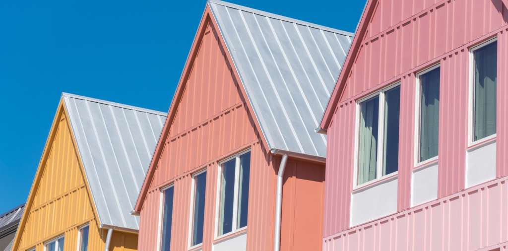 A metal roof with pastel siding 