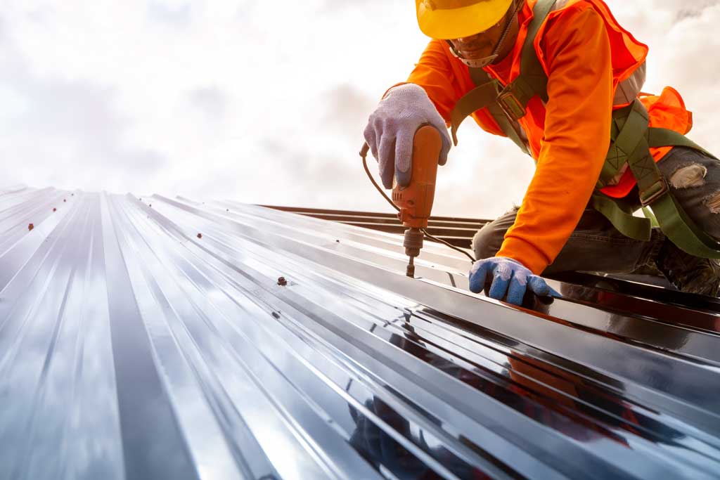 A roofer installing a metal roof