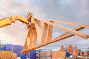 A forklift raising trusses up onto stud walls