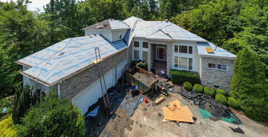 A drone shot of a large house getting a new roof