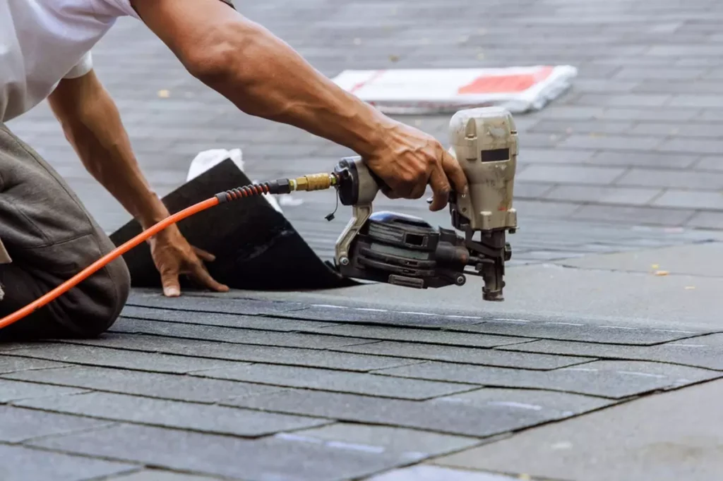 A roofer with a nail gun